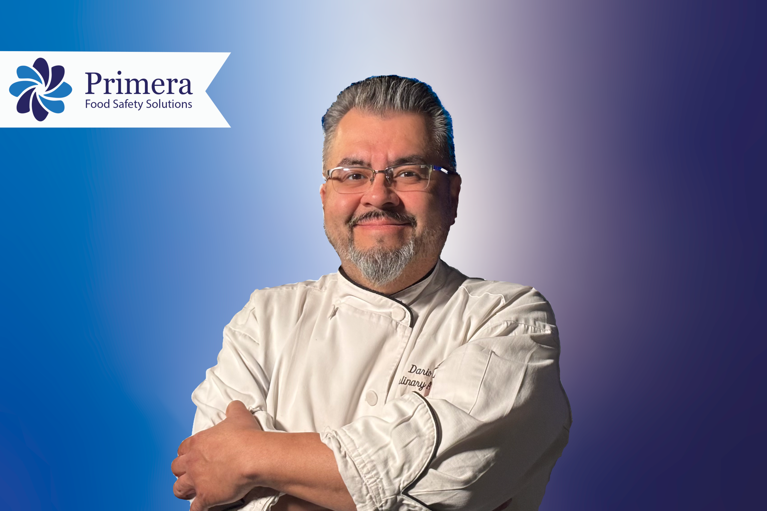 Chef Dario Chavez standing looking at the camera with arms crossed looking in charge and happy.